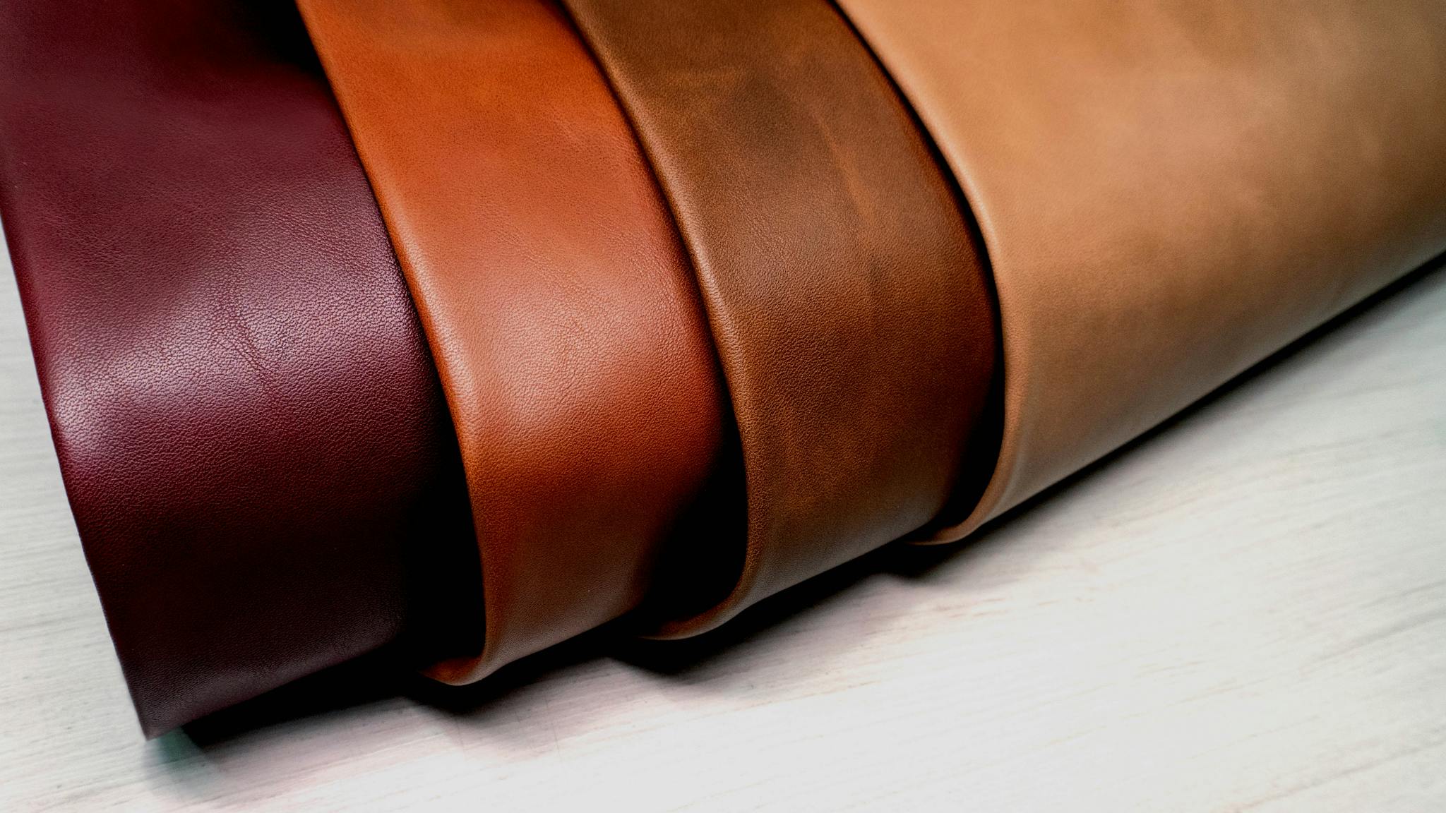 A selection of high-quality leather rolls in diverse shades showcased on a light surface.