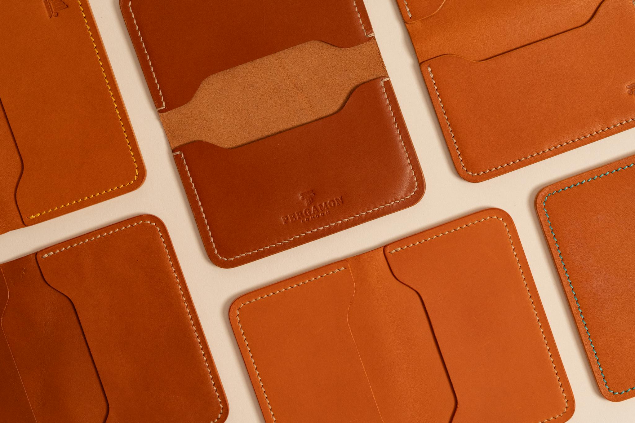 Stylish brown leather wallets with unique stitching, perfect for luxury and fashion lovers.